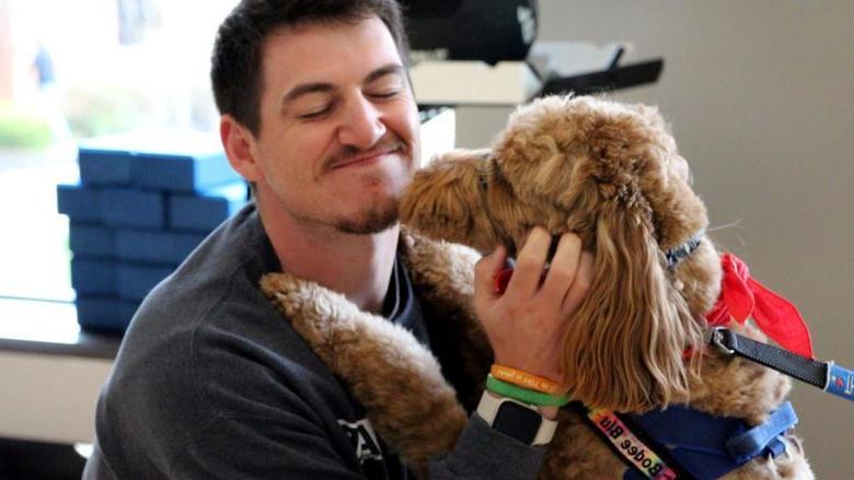 365英国上市杜波依斯分校 third-year student Jeff Romano enjoys the comfort a therapy dog gives him during one of the events of De-Stress Fest at 365英国上市杜波依斯分校.
